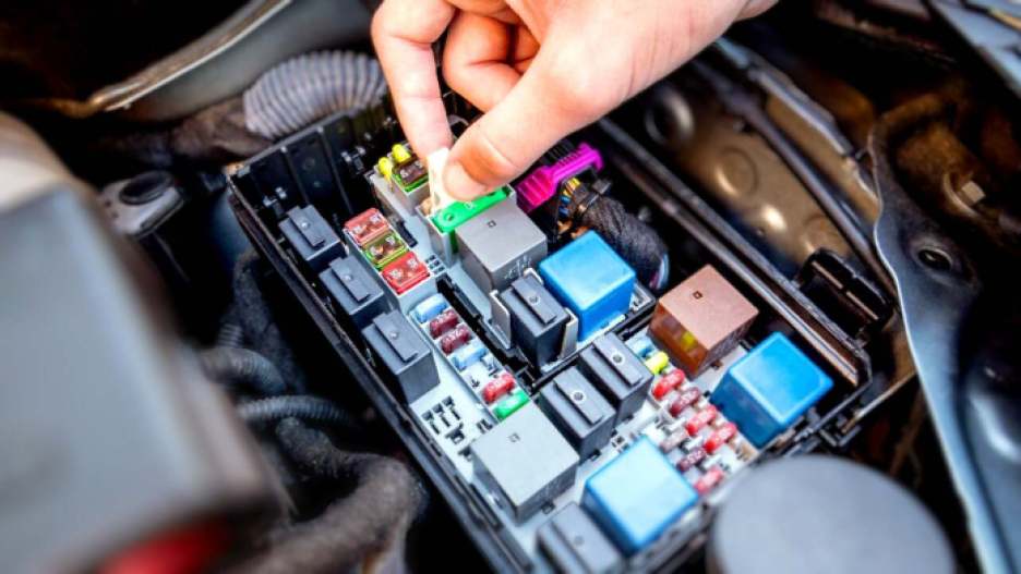 A typical power distribution box with fuses and mechanical relays.