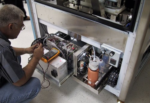 A man testing a circuit board for faults.